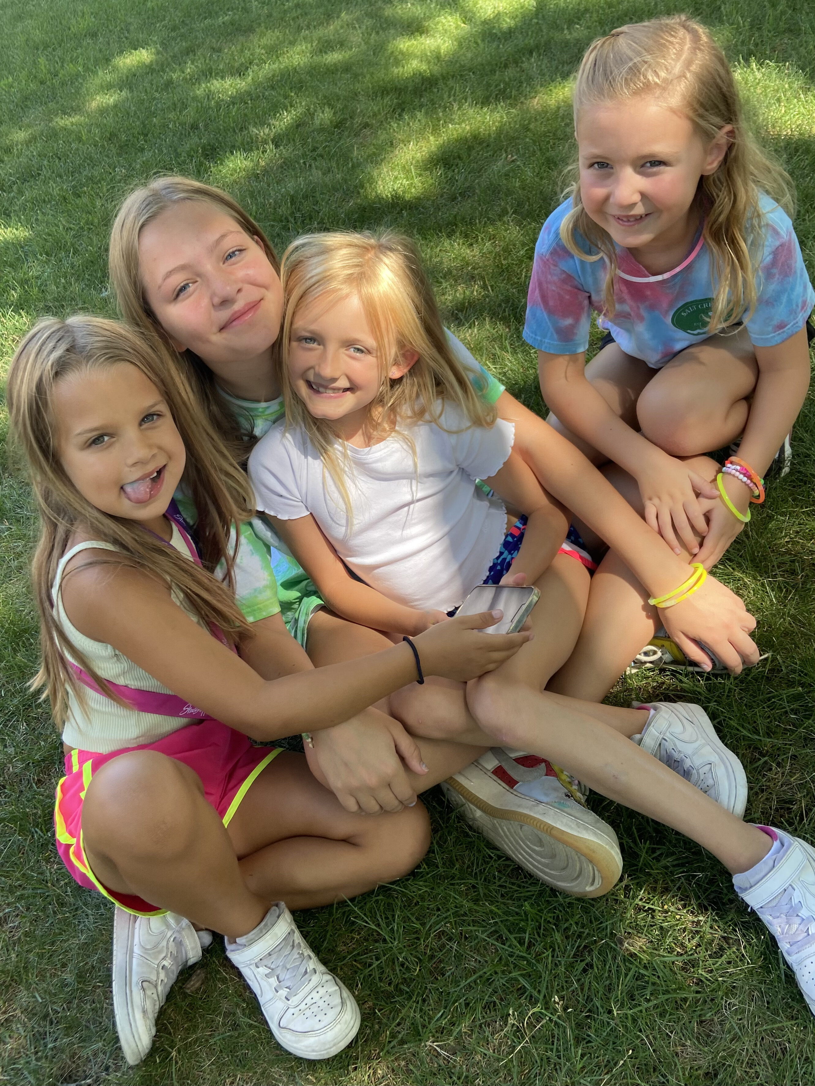 Kids sitting together on the grass at camp