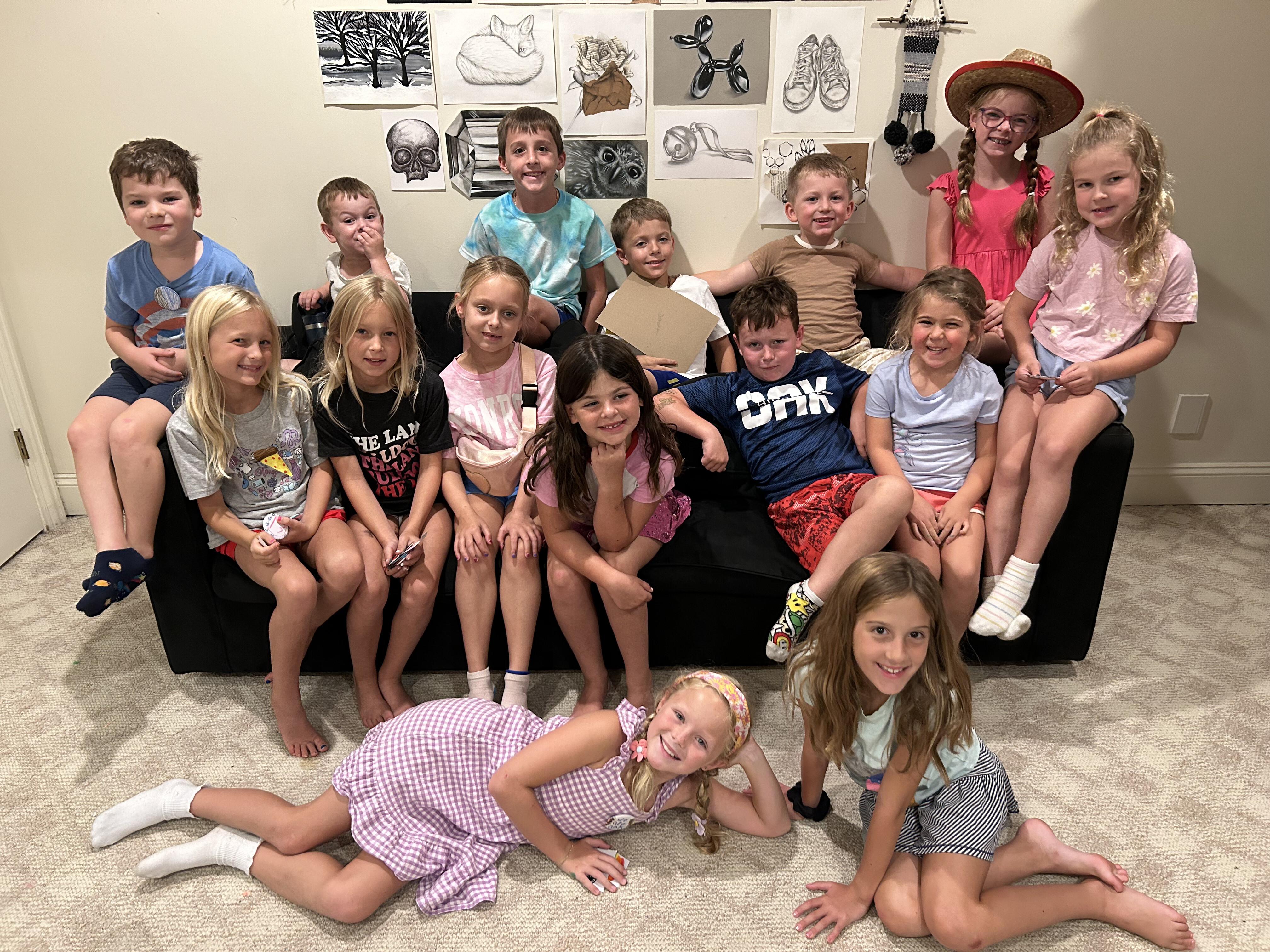 Kids class group posing with charcoal art on the wall