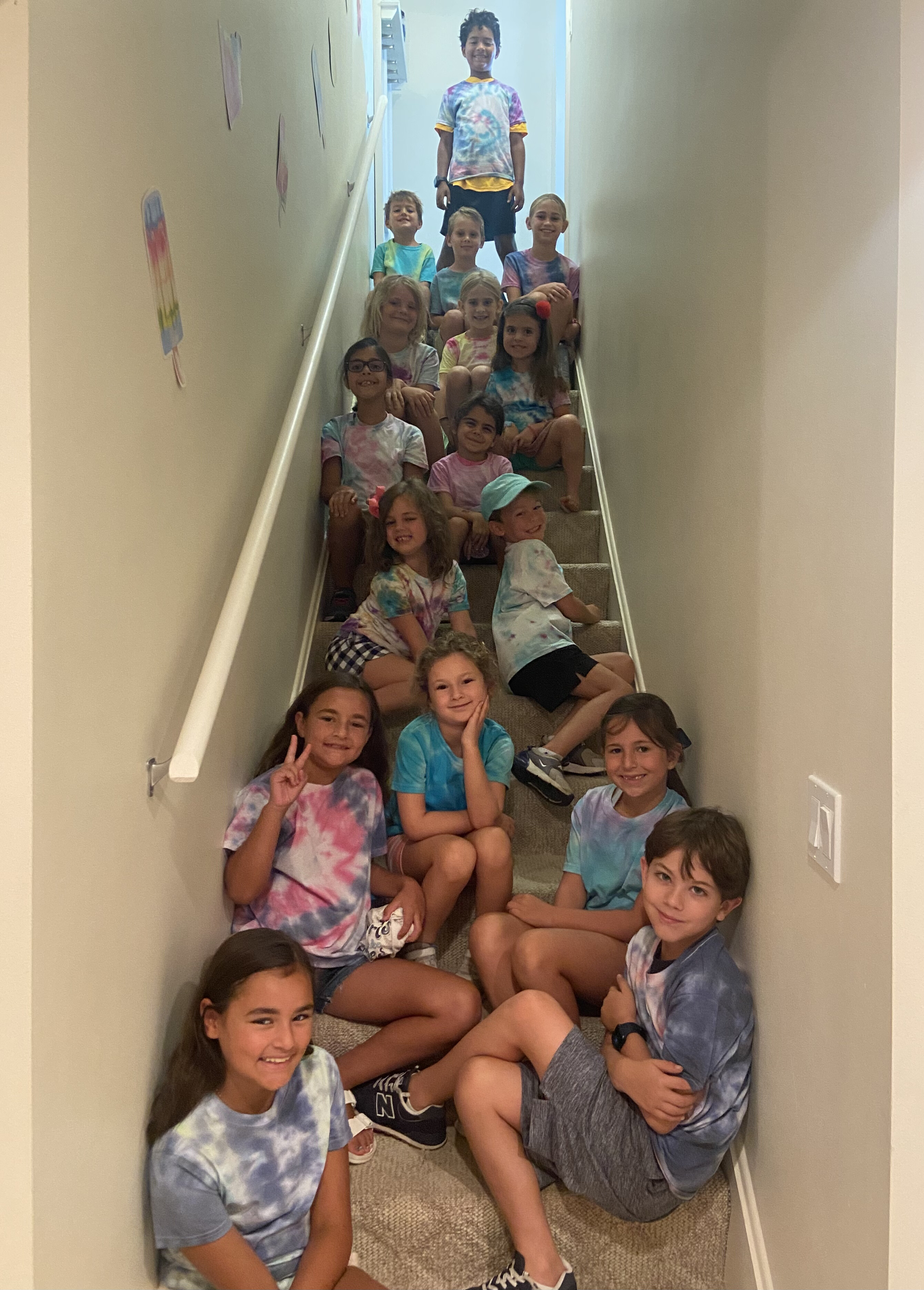 Camp kids on staircase wearing tie-dye shirts they made